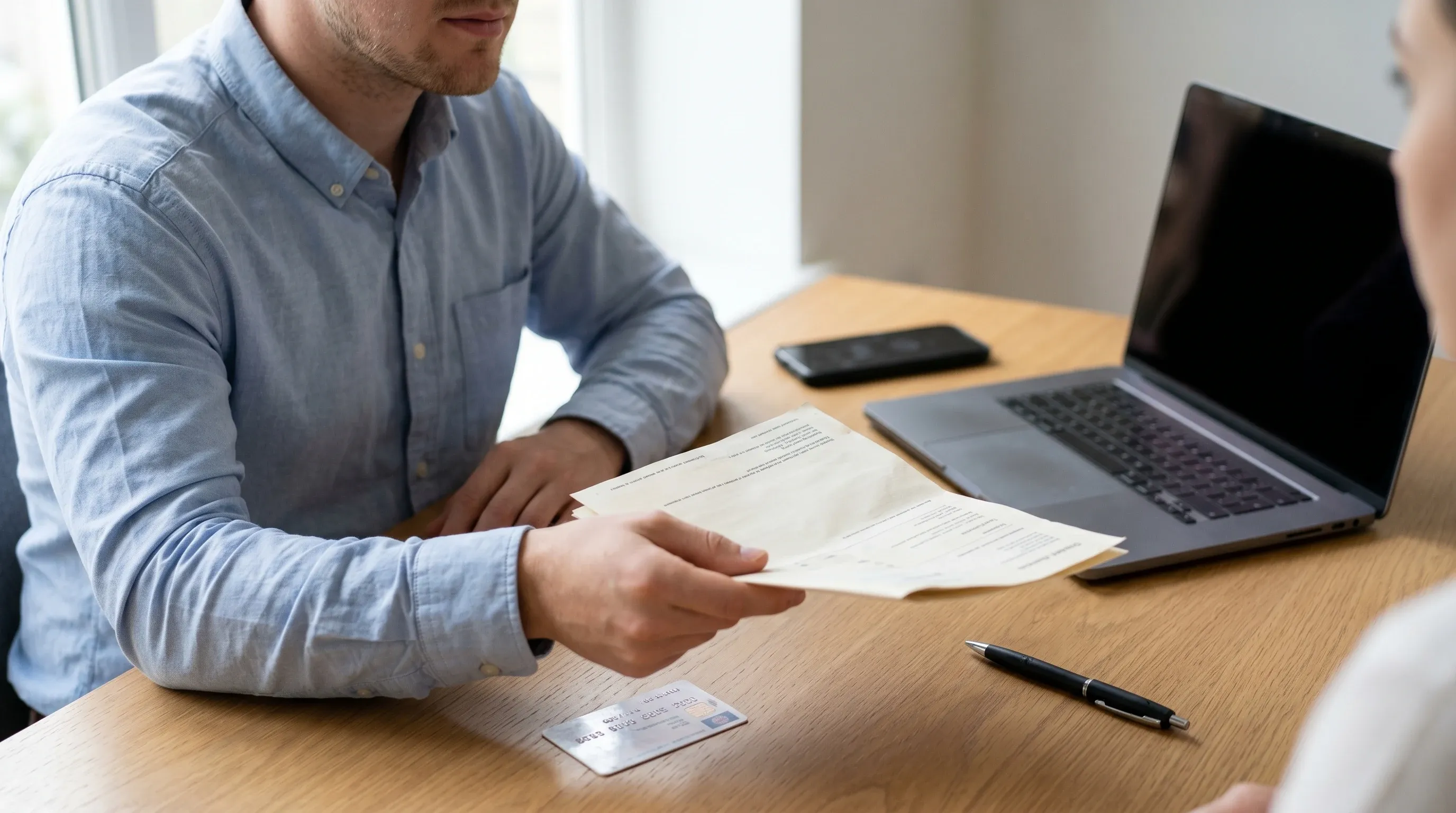 Pracownik w biznesowym stroju przekazuje dowód rejestracyjny i polisę oc leasingu przy biurku
